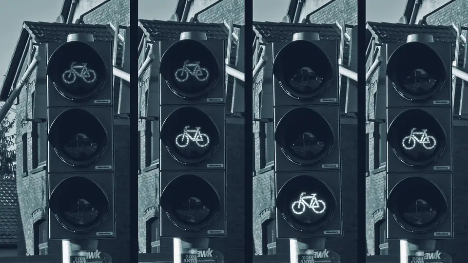 Vier Ampeln nebeneinander, die gleichzeitig Rot, Gelb und Grün zeigen